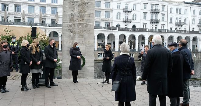 Mehrere, in schwarz gekleidete Personen stehen vor der Ernst-Barlach-Stele.