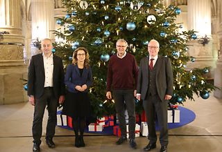 Carsten Krüger, Carola Veit, Axel Grassmann und Dr. Matthias Bartke vor dem Weihnachtsbaum in der Rathausdiele