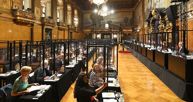 Eine Bürgerschaftssitzung findet im Großen Festsaal des Rathauses statt. Zwischen den Abgeordneten befinden sich Trennwände.