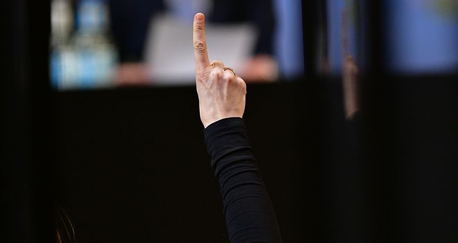Es ist eine Hand mit gehobenem Zeigefinger bei einer Abstimmung im Rahmen einer Bürgerschaftssitzung zu sehen.