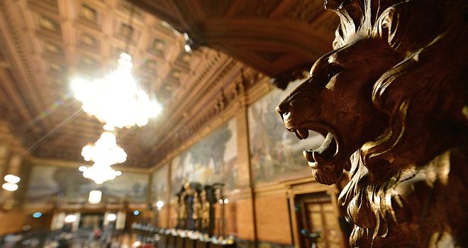 Im Vordergrund ist das Profil einer Löwen-Skulptur zu sehen, im Hintergrund der Aufbau für eine Bürgerschaftssitzung im Großen Festsaal.
