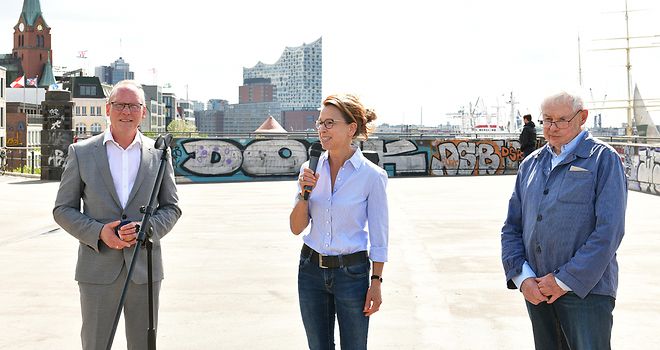 Thomas Fuhrmann, Carola Veit und Fritz Currle stehen an den Landungsbrücken und halten eine Ansprache.