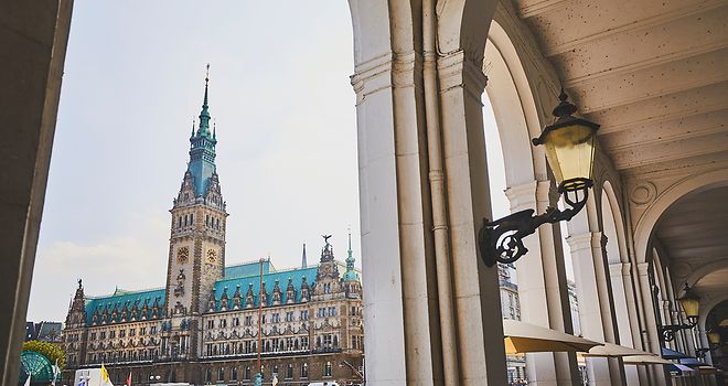 Blick auf durch die Alsterarkaden auf das Hamburger Rathaus.
