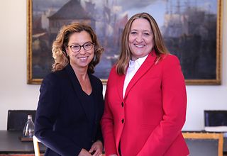 Präsidentin Carola Veit steht links neben der niedersächsischen Landtagspräsidentin Dr. Gabriele Andretta. Im Hintergrund ist ein Besprechungstisch und ein großes Bild an der Wand zu sehen.