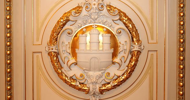 Mit Gold ausgelegtes Holzornament des Stadtwappens in den repräsentativen Räumen des Hamburger Rathauses.