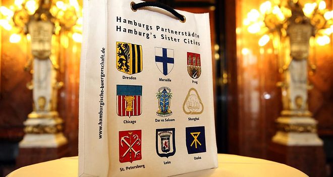 Tragetasche, auf der die Wappen aller neun Partnerstädte Hamburgs gedruckt sind.